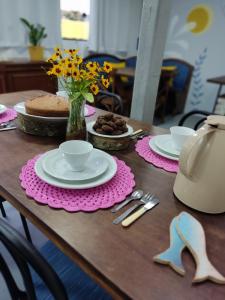 a table with plates of food and a cake at Maga hospedagem in Penha