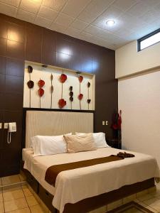 1 dormitorio con 1 cama grande con flores rojas en la pared en Posada Vista Tepoz, en Tepoztlán