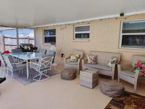 eine Terrasse mit einem Tisch, Stühlen und einem Tisch in der Unterkunft Private & Screened in Pool in Port Richey