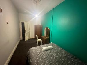 sypialnia z łóżkiem i zieloną ścianą w obiekcie Railway Hotel w mieście Rakaia