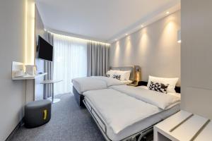 a hotel room with two beds and a television at Holiday Inn Express - Goettingen, an IHG Hotel in Göttingen