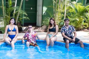 un grupo de personas sentadas en una piscina en Samuva Campestre en Managua