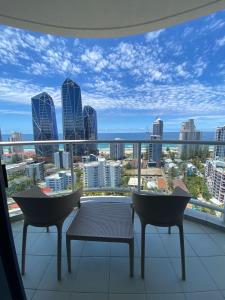 a balcony with two chairs and a view of the city at Ocean View Studio Apt - Surfer's Paradise in Gold Coast