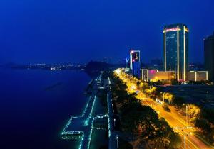 a city at night with a river and buildings at Crowne Plaza Zhenjiang by IHG in Zhenjiang