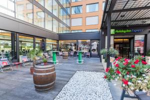 ein Einkaufszentrum mit Tischen, Stühlen und Blumen in der Unterkunft Holiday Inn Express Zürich Airport, an IHG Hotel in Rümlang