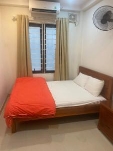 1 dormitorio con 1 cama con manta roja y ventana en Phòng đơn có cửa sổ thoáng mát khép kín + Thang máy, en Hanói