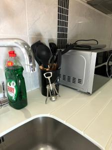 a kitchen counter with a sink and a microwave at Birmingham City Centre Rotunda. in Birmingham