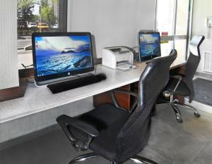 a desk with a computer and a printer on it at Holiday Inn Express and Suites Calgary, an IHG Hotel in Calgary