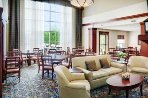 a hotel lobby with tables and chairs and a dining room at Staybridge Suites Oakville Burlington, an IHG Hotel in Oakville