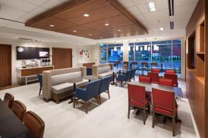 a waiting area in a hospital with tables and chairs at Holiday Inn Express & Suites Terrace by IHG in Terrace