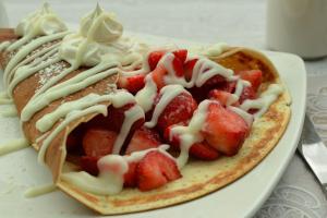 a plate of food with strawberries and white sauce at Holiday Inn Hotel & Suites London, an IHG Hotel in London