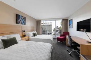 a hotel room with two beds and a desk at Crowne Plaza Queenstown by IHG in Queenstown +184 photos