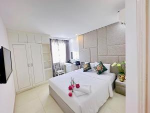 Un dormitorio con una cama blanca con flores. en Aodai Inn Saigon en Ho Chi Minh