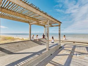 a group of people sitting on a boardwalk at the beach at Maison calme près plage - 6 pers - Animaux admis - FR-1-540-284 in Notre-Dame-de-Monts