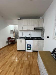 een keuken met witte kasten en een houten vloer bij Mini departamento in Trujillo