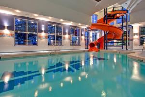 a swimming pool with a slide in a building at Holiday Inn Express Calgary South, an IHG Hotel in Calgary