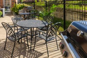an outdoor table and chairs with a grill and a table and chairs at Holiday Inn Express Hotel & Suites North Bay by IHG in North Bay