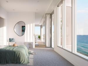 Dormitorio con cama, espejo y océano en Kirra Point Holiday Apartments en Coolangatta