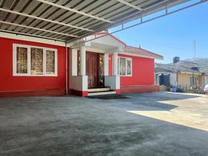 un edificio rosso con una porta rossa di QUEENS COTTAGE - individual cottage a Ooty