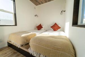 Duas camas sentadas uma ao lado da outra num quarto em RuGu Glamping Resort em Miyako Island