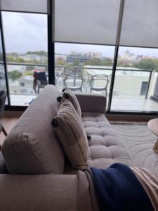 ein Sofa mit Kissen darauf in einem Zimmer mit Fenstern in der Unterkunft Gold location Melbourne CBD in Melbourne