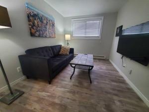 a living room with a couch and a coffee table at Central Private 1BR Apt. w/Free Prkg + Fast Wi-Fi in Sault Ste. Marie