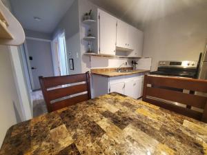 a kitchen with a large marble table and chairs at Central Private 1BR Apt. w/Free Prkg + Fast Wi-Fi in Sault Ste. Marie