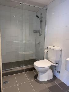 ein Bad mit einem WC und einer Glasdusche in der Unterkunft Gold location Melbourne CBD in Melbourne