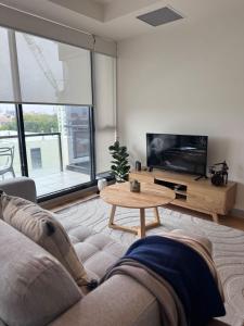 ein Wohnzimmer mit einem Sofa und einem Tisch in der Unterkunft Gold location Melbourne CBD in Melbourne