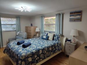 a bedroom with a bed and a chair and windows at Comfortable, Sunny, Quiet Neighborhood in Port Richey