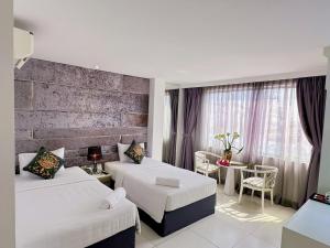 una camera d'albergo con due letti e un tavolo di Aodai Inn Saigon ad Ho Chi Minh