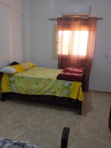 una camera da letto con un letto con una coperta gialla e una finestra di Rass Suder a Ras Sedr