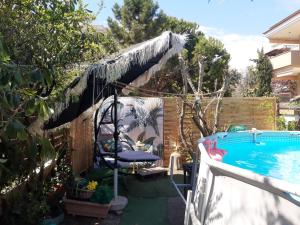 einen Hinterhof mit einem Pool und einem Zaun in der Unterkunft maisonette with garden in Peraia
