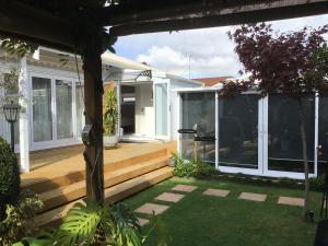 a house with a wooden deck with windows at Secret Garden Guest Suite in Tauranga