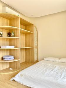 a bedroom with a bed and wooden shelves at Lotus Home Quảng Ngãi in Quảng Ngãi