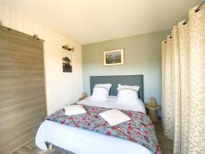 sypialnia z łóżkiem z białą pościelą i poduszkami w obiekcie Maison Saint-Gildas-de-Rhuys, 4 pièces, 6 personnes - FR-1-639-112 w mieście Saint-Gildas-de-Rhuys