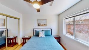 Un dormitorio con una cama azul y una ventana. en Canyon Portal #469, en Moab 41 fotos más