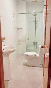 een badkamer met een douche, een toilet en een wastafel bij Khách Sạn Tường Vy in An HÃ²a