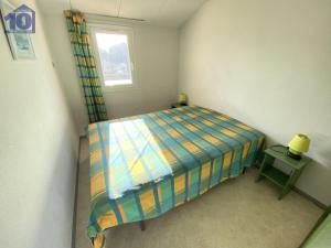 a small bedroom with a bed and a table at Maison Vendres, 3 pièces, 6 personnes - FR-1-781-40 in Port-Vendres