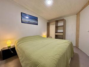 um quarto com uma cama verde num quarto em Appartement Saint-Georges-d'Oléron, 3 pièces, 4 personnes - FR-1-246A-296 em Saint-Georges-dʼOléron
