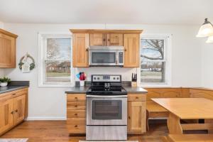 a kitchen with a stove and a microwave at 3BR Cottage Near Downtown Kingsport in Kingsport