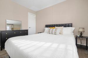 ein weißes Schlafzimmer mit einem großen Bett und einem Spiegel in der Unterkunft 2BR house minutes from Holston Valley & Eastman in Kingsport