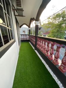 a balcony with green grass on the side of a house at #KangaQHomestay99 in Kangar