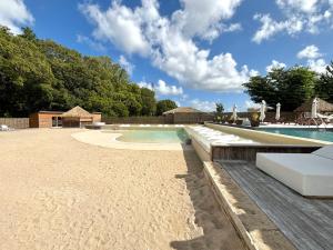 un complexe avec une piscine et une plage de sable dans l'établissement La Saranah - Blue Dream, Piscine, Plage, à Grand-Bourg