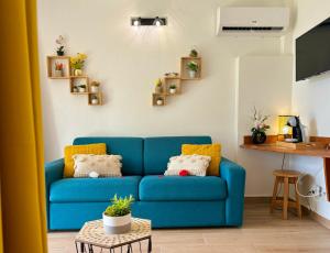 - un canapé bleu dans le salon avec une table dans l'établissement La Saranah - Blue Dream, Piscine, Plage, à Grand-Bourg