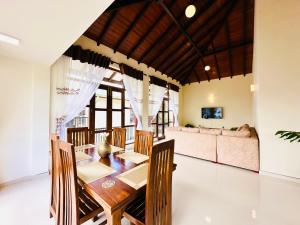 a dining room with a table and a couch at Bloomingdale Bungalows - Nuwaraeliya in Sita Eliya