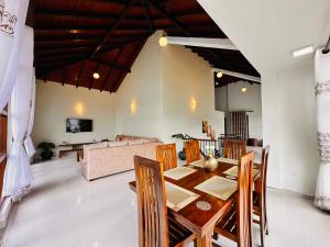 a dining room and living room with a table and chairs at Bloomingdale Bungalows - Nuwaraeliya in Sita Eliya