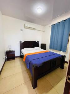 - une chambre avec un lit et un rideau bleu dans l'établissement Esparza-PURA VIDA-Tu espacio tranquilo y acogedor., à Esparza