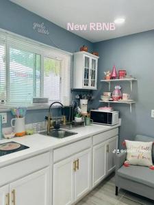 a kitchen with a sink and a microwave at Fancy studio private entrance in Selden