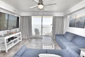 ein Wohnzimmer mit einem blauen Sofa und einem TV in der Unterkunft 0902 Waters Edge Resort condo in Myrtle Beach